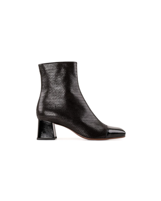 A single black ankle boot with a textured, snakeskin-like pattern on the shaft and a glossy patent leather toe cap, set against a plain white background.